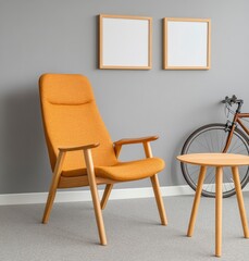Mustard yellow armchair with wooden legs, two blank frames on grey wall, bicycle and small wooden side table in a modern room. Light neutral tones