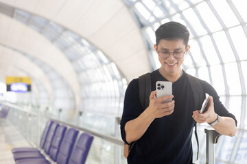 close up young asian man smile and looking while holding passport ,ticket and smartphone in airport...