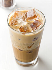 Iced Coffee in Glass: Refreshing iced coffee with ice cubes in a clear glass, perfect for a hot summer's day. The creamy texture and rich color invite you to take a sip.