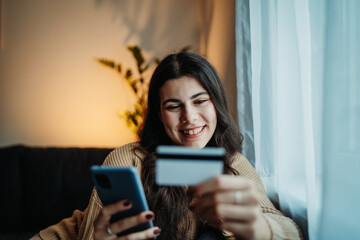 Young caucasian woman buy or pay online on smart phone using credit card	
