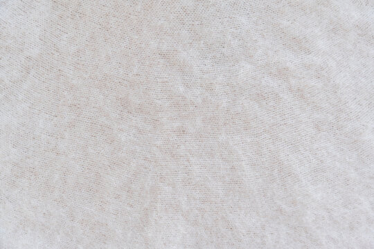 Close-up of soft white mohair fabric with delicate fibers and fluffy textured