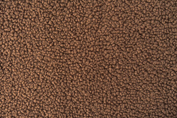 Macro shot of brown fashion teddy sherpa fleece fabric showcasing its soft curly texture. © Valeriia