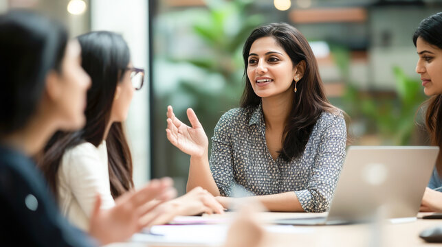 Indian businesswoman leading meeting with her team in modern office