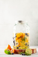 Detox infused water in glass. Refreshing summer homemade cocktail with fruit, berries and citrus