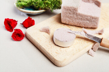 Florist at work: woman shows how to make miniature floral arrangement with tiny roses (rosa spray heads), moss and used tealight candle container. Step by step, tutorial.