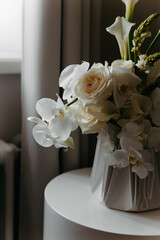 A vase with stunning white flowers sits elegantly on a table