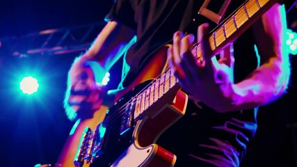 Close up guitarist playing live on stage at music event
