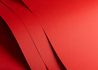 Fiery vermilion red paper background with a smooth texture and overlapping curved folds. Warm coral...