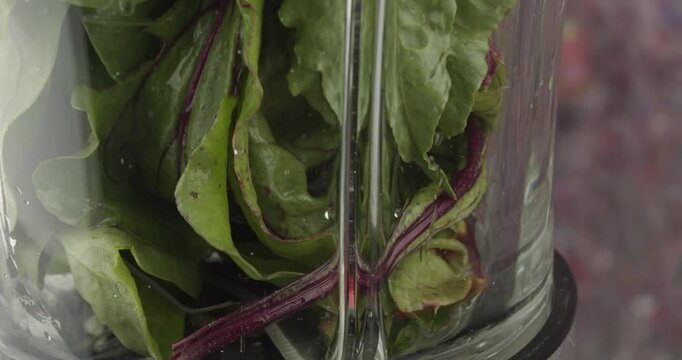 mixing a green smoothie in an electrical blender closeup 4k 30fps