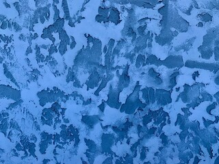 The surface displays intricate patterns formed by frozen blue paint, reminiscent of natural ice...