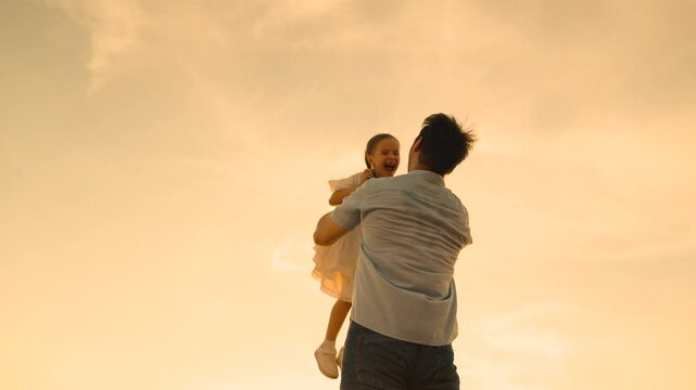 father throws child kid daughter into sky, silhouette happy family, children dream flying airplane pilot, family silhouette against sunset, daughter flying high, family twilight play, child in sky