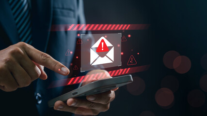 Concept of email warning and phishing scam risk as businessman using smartphone taps on alert...
