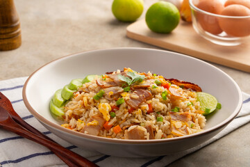 Fried Rice with Crispy Bacon.Stir fried jasmine rice with bacon carrot and eggs in white plate.