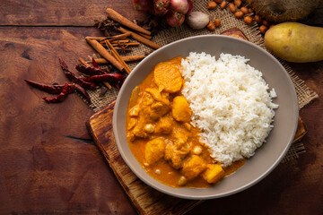 Massaman Curry with Chicken and Potatoes with cooked rice in a plate.Top view