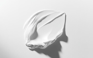 White cream smear on white surface with shadow, cosmetic product sample