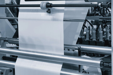Automatic polyethylene plastic bag production machine with lighting effect. Close-up of the roller...