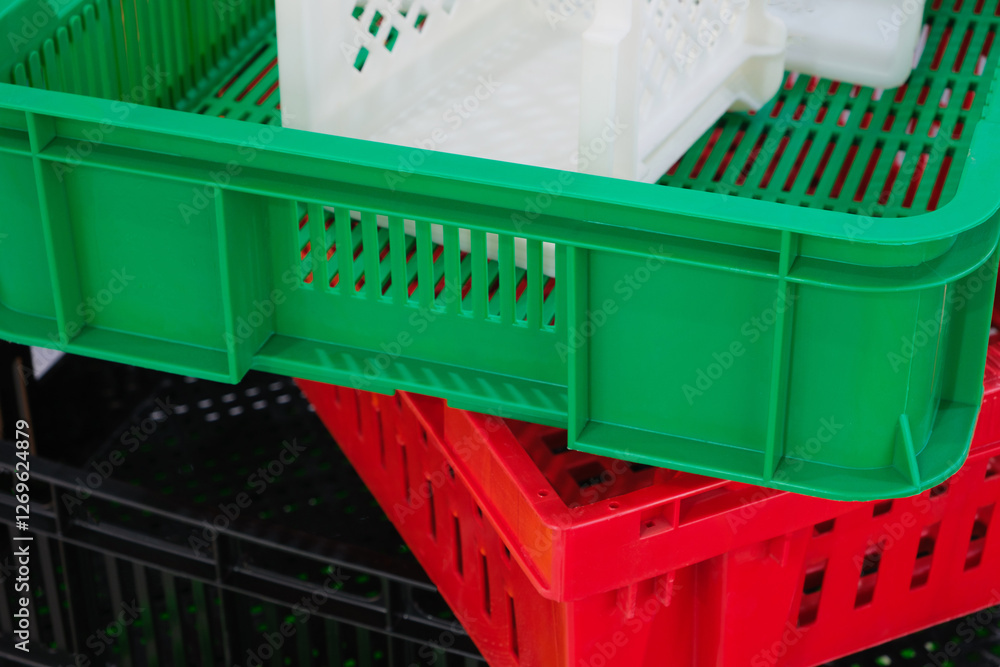 Poster a stack of plastic containers in different colors, including green, red, and white. the green contai