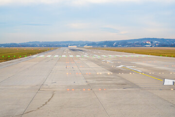 Runway view at an airport showing clear path for takeoff on a cloudy day