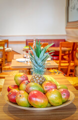 Paris, France - 02 16 2025: A bamboo fruit platter consisting of pineapples, bananas, mangoes and clementines.