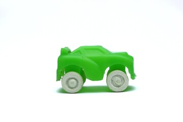 Close up studio shot of a small green plastic toy car on white background