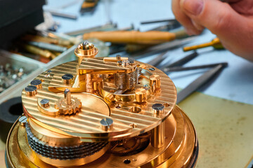 Intricate clock mechanism showcases craftsmanship during delicate assembly process