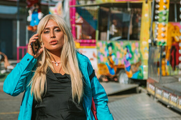 young woman in amusement park with mobile phone