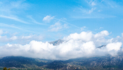 Cumulus Congestus Clouds against blue sky over  montains.