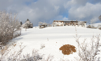 Fototapeta premium Winterzeit, Winterlandschaft, blauer Himmel mit Wolken, Haus im Schnee