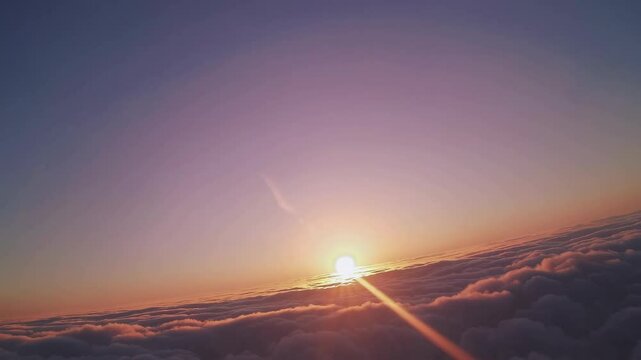 Gorgeous sunset above the clouds in the sky. Sunrays breaking through the clouds. amera rises above the clouds to see the bright sunset sky and the sun