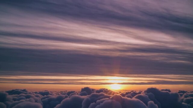 Gorgeous sunset above the clouds in the sky. Sunrays breaking through the clouds. amera rises above the clouds to see the bright sunset sky and the sun