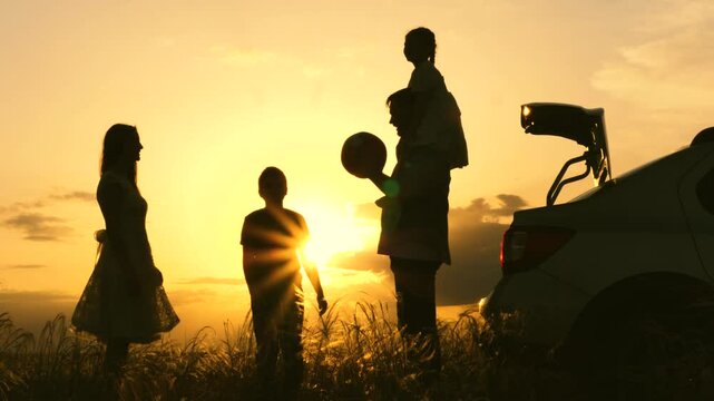 family ball game sunset by car. travel child parents car. people nature. fun child fun with mother father park. air ball flies air. child throws ball sunset dad mom. happy children with parents park