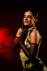 Dancing woman in vibrant outfit captivates with bachata moves in smoky atmosphere during a...