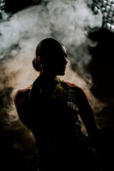 Dynamic latina dancer in silhouette surrounded by swirling smoke at a nighttime performance