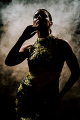 Latina dancer performs in dark smoke with graceful movements and expressive choreography