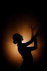 Dancer expresses passion in dark with flowing movements and smoke, showcasing Latin dance styles at...