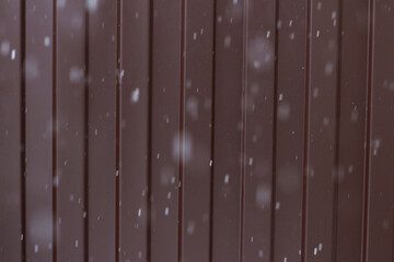 Perspective along a metal fence. Snowflakes falling down. Background. Texture.