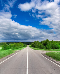 Long road with a clear blue sky and trees in the background
