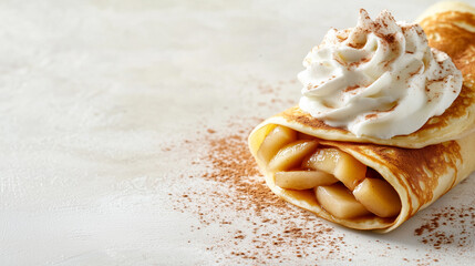 Rolled crepes filled with caramel apples and cinnamon, topped with fresh whipped cream and cinnamon.