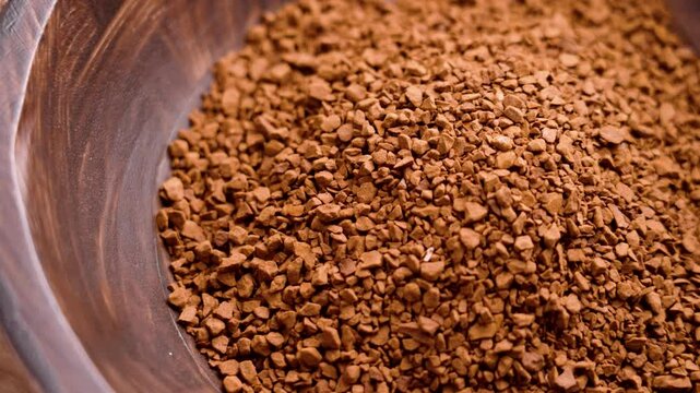 Soluble coffee granules in rustic wooden bowl. Aromatic morning instant drink ingredient.