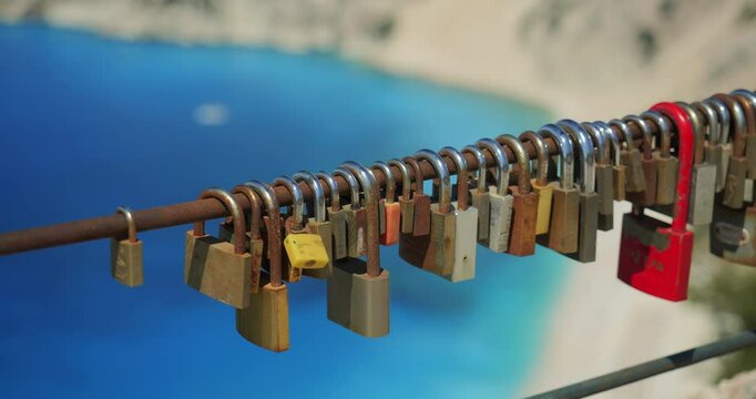 Colored love locks on a fence on top of the mountain above Myrtos beach in Kefalonia island, Greece