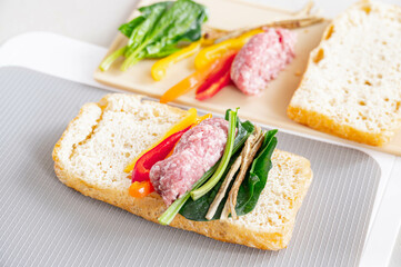 半分に切った栃尾揚げに野菜と挽肉を乗せる