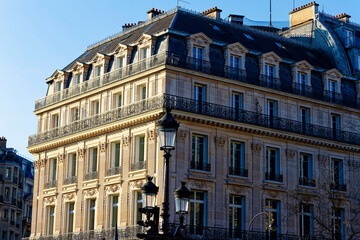 Exterior architecture of Traditional French house with typical balconies and windows in Paris. Traditional Parisian street light in the foreground.