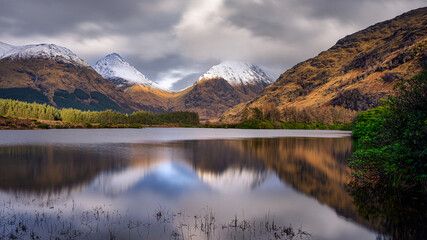Fototapeta premium Winter reflections in Lochan Urr, a small lochan found in Glen Etive in the Scottish Highlands.