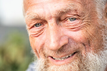 Portrait of an elderly man in retirement, enjoying peaceful moments outdoors, smiling contently, showing physical and mental wellbeing, wearing casual clothes, close-up with wrinkles, gray hair, 