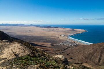 Above Sea Level/This is an aerial view of a volcanic landscape surrounding the village of Caleta De Famara and Playa De Famara beach, Shot in Lanzarote, Canary Islands, Spain.