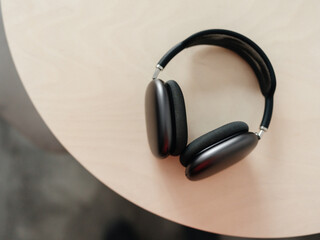 modern gray headphones on beige wooden The concept of music and fashion. Minimalism.