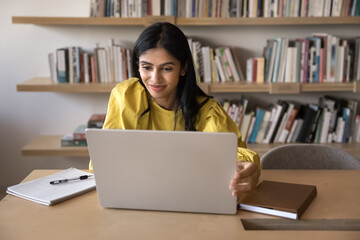 Focused on research. Smiling young woman university student scientist study online at modern...