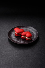 Red macaroons in the shape of a heart, sweets for the holiday of Valentine's Day