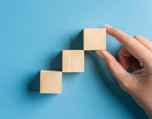 main qui pose des cubes de bois pour marquer une évolution, une construction, un travail, en ia