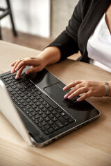 Female hands typing on laptop, close-up